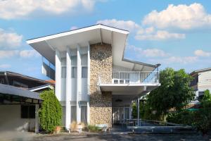 a white building with a balcony on the side at 清迈古城柚子别墅塔佩门里 in Chiang Mai
