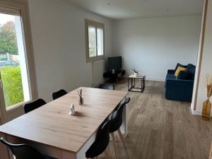 ein Wohnzimmer mit einem Holztisch und Stühlen in der Unterkunft Maison avec jardin proche circuit des 24h in Moncé-en-Belin