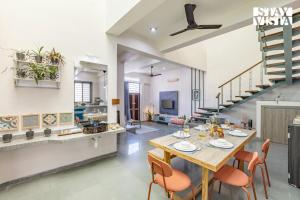 a kitchen and living room with a table and chairs at StayVista at Ikigai - Pool, AC & Terrace in Udaipur
