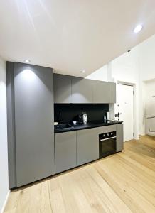 a kitchen with grey cabinets and a wooden floor at Mgm Property - Wonderful Loft Tartaglia in Milan +24 photos