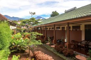 a house with a courtyard with trees and plants at Famoris Cottages in Tetebatu +10 photos
