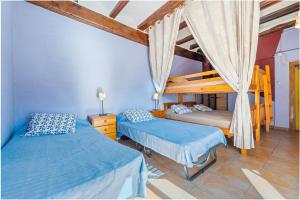 two beds in a bedroom with blue walls at Ca La Germandat Paüls in Paúls