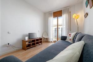 a living room with a blue couch and a tv at Una joya en Tarragona in Tarragona