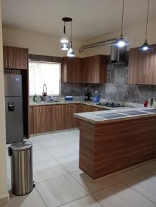 a kitchen with wooden cabinets and a stainless steel refrigerator at Casa con casa club en la Paz BCS in La Paz