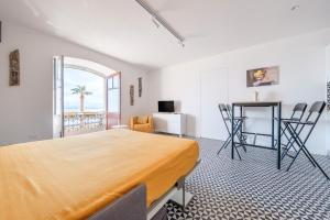 ein Schlafzimmer mit einem Bett und einem Tisch und Stühlen in der Unterkunft I Mezzanini - Palazzo Bonaccorsi in Milazzo