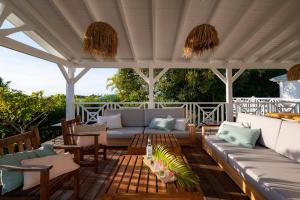 a patio with a couch and chairs under a pergola at Villa Blanche in Grand-Bourg +70 photos