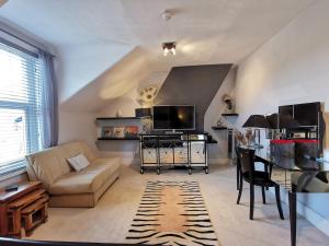 a living room with a couch and a table at Victoriana Duplex Apartment in Stratford-upon-Avon