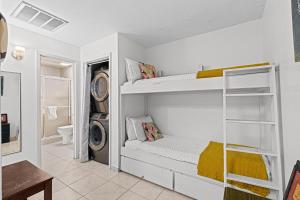 Habitación con 2 literas y lavadora. en Birdies Landing At Butterfly Park Beach Access, en South Padre Island