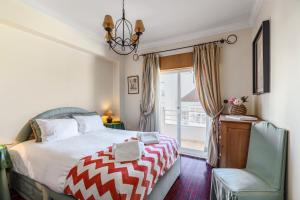 a bedroom with a bed and a chair and a window at Setúbal Dreams in Setúbal