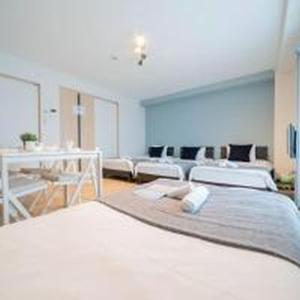 a large room with two beds and a table at Mutsumi Konohana 601 むつみ庵此花 601 in Osaka +77 photos