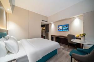 Postel nebo postele na pokoji v ubytování Mei Gang Hotel