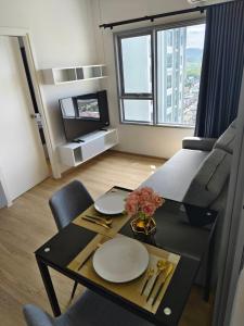 ハジャイにある1 Bedroom condo next to Central Hatyaiのリビングルーム(テーブル、皿付)