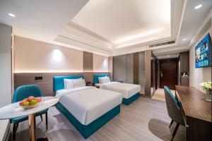 Postel nebo postele na pokoji v ubytování Mei Gang Hotel