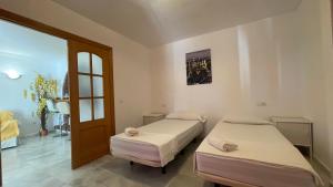 dwa łóżka w pokoju z drzwiami w obiekcie Apartamento Golf Beach w mieście Benalmádena +37 zdjęć