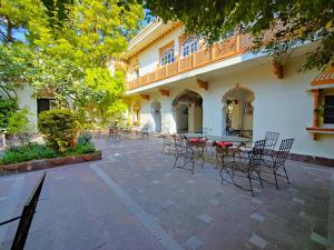 a patio with chairs and tables in front of a building at Palkiya Haveli - Heritage Hotel in Kota