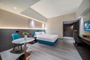 Postel nebo postele na pokoji v ubytování Mei Gang Hotel