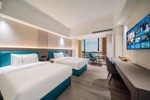 Postel nebo postele na pokoji v ubytování Mei Gang Hotel