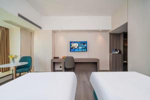 Postel nebo postele na pokoji v ubytování Mei Gang Hotel