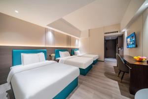 Postel nebo postele na pokoji v ubytování Mei Gang Hotel