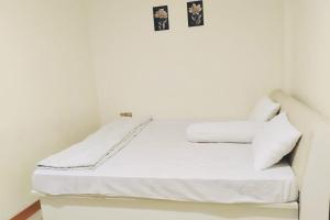 TanjungubanRedDoorz Near Tj Uban Bintan Utara的房间里有一张铺着白色床单和枕头的床