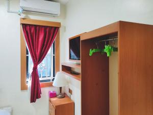 TanjungubanRedDoorz Near Tj Uban Bintan Utara的一间卧室设有红色窗帘和窗户