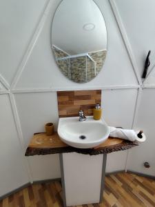a bathroom with a sink and a mirror at Domotel Aysen 4 personas excelente conectividad in Puerto Aisén +11 photos