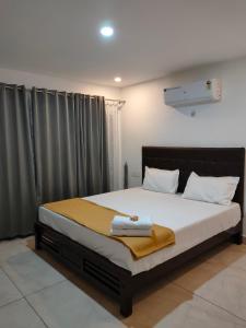 a bedroom with a large bed with white pillows at th lagoon in Mayyanād