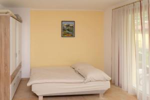 a bed in a bedroom with a picture on the wall at Cozy Garconniere near Innsbruck in Völs