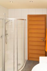 a shower with a glass door in a bathroom at Cozy Garconniere near Innsbruck in Völs