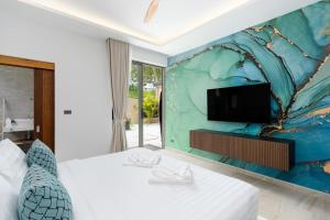 ein Schlafzimmer mit einem weißen Bett und einem TV an der Wand in der Unterkunft Villa Kelapa Koh Samui in Koh Samui  + 40 Fotos