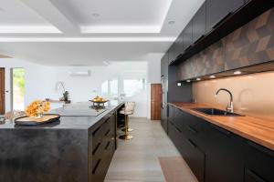 eine Küche mit schwarzen Schränken und einer Arbeitsplatte in der Unterkunft Villa Kelapa Koh Samui in Koh Samui 