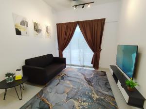 a living room with a black couch and a tv at Kampar Lake House - Bandar Baru Kampar City Centre in Kampar