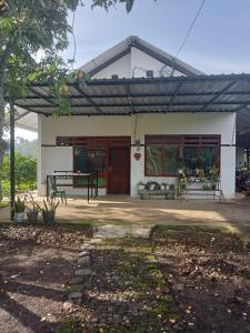 ein kleines weißes Gebäude mit einer roten Tür in der Unterkunft Farm House , Mountain View, Coffee Vegetable Farm BATU CITY in Tlekung