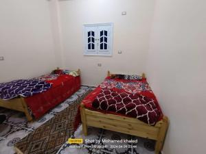 a bedroom with two beds and a window at Amoun أمون in Siwa