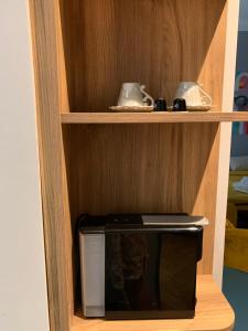 a small microwave in a wooden shelf with at Pop's Apartments in Belgrade