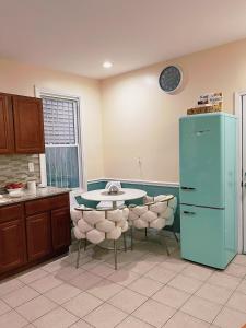 a kitchen with a table and a blue refrigerator at 3 bdrm stay! Trippy King Suite by Dwtwn Nwk in Newark