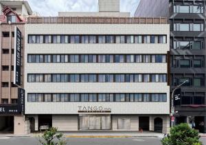un grande edificio bianco con un cartello sopra di Tango Inn Taipei Kaifong a Taipei