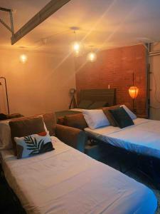 a living room with two beds and a couch at BRICK CITY VILLA! 20 minutes from NYC in Newark