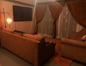 a living room with two couches and a flat screen tv at BRICK CITY VILLA! 20 minutes from NYC in Newark +53 photos