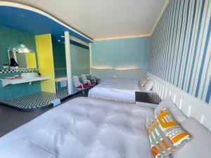a room with two beds and a couch in it at Nanwan Haiye Villa in Hengchun