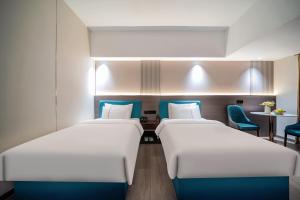 Postel nebo postele na pokoji v ubytování Mei Gang Hotel