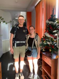 Un uomo e una donna in piedi di fronte a un albero di Natale di The Orange House Weligama a Weligama