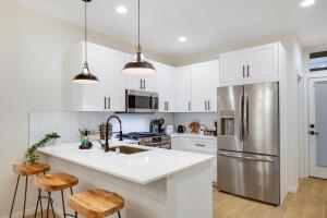 a kitchen with white cabinets and a stainless steel refrigerator at Perch - Ballard Bliss in Seattle