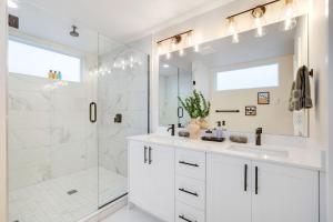 a white bathroom with a shower and a sink at Perch - Ballard Bliss in Seattle +30 photos
