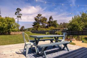 a picnic table with two chairs and a picnic bench at Sea La Vie in Fort Bragg