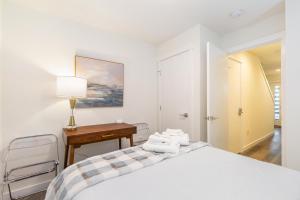 a white bedroom with a bed and a desk at Perch - Roosevelt Retreat in Seattle