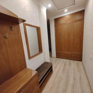 een lege kamer met een spiegel en houten kasten bij 1 bedroom apartment in Doesjanbe