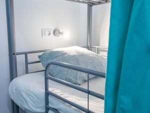 a bedroom with a bunk bed with a blue curtain at Medano Nest Hostel in El Médano