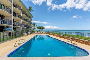 - une piscine dans un complexe avec l'océan en arrière-plan dans l'établissement Perch - Seaside Serenity Kahana Reef 109, à Kahana