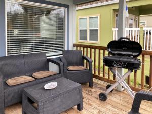 a screened porch with a couch and chairs and a grill at Boat House in Fort Bragg